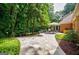 Stone patio perfect for outdoor entertaining with mature trees and a view of the home's exterior at 3030 Spalding Dr, Sandy Springs, GA 30350