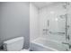 Clean bathroom featuring subway tile, a shower-tub, and neutral gray walls at 3030 Spalding Dr, Sandy Springs, GA 30350