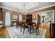 Dining room boasts a wooden table, chandelier, hardwood floors, and abundant natural light at 3030 Spalding Dr, Sandy Springs, GA 30350