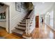Bright hallway with hardwood floors, white trim, and staircase with carpet at 3030 Spalding Dr, Sandy Springs, GA 30350