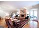 Bright living room boasts hardwood floors, a brick fireplace, a comfortable seating arrangement, and ample natural light at 3030 Spalding Dr, Sandy Springs, GA 30350