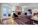 Spacious living room features hardwood floors, a brick fireplace, and french doors to an outdoor space at 3030 Spalding Dr, Sandy Springs, GA 30350