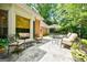 Stone patio with seating area, outdoor dining set, umbrella and beautifully landscaped backyard at 3030 Spalding Dr, Sandy Springs, GA 30350