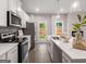 Bright kitchen boasts white cabinets, stainless steel appliances, and a center island with quartz countertops at 5615 Hislop Ln # 82, Mableton, GA 30126