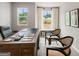 Study featuring a wooden desk, two windows, and two comfortable chairs at 5615 Hislop Ln # 82, Mableton, GA 30126