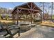Inviting outdoor lounge area with a stone fire pit, comfortable seating, and a wooden pavilion structure at 5615 Hislop Ln # 82, Mableton, GA 30126