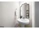 Cozy powder room featuring a pedestal sink, decorative mirror, and neutral color palette at 774 Belrose Dr, Smyrna, GA 30080