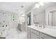 Bright bathroom featuring double sinks, tiled walls, and a glass-enclosed shower at 774 Belrose Dr, Smyrna, GA 30080
