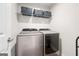 Modern laundry room with silver front load washer and dryer with decor shelf on top at 774 Belrose Dr, Smyrna, GA 30080