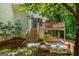 Backyard featuring wooden stairs leading to a deck with abundant trees and natural vegetation at 210 Hunters Vw, Roswell, GA 30075