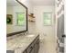 Bathroom with granite countertops, white tile flooring, decorative shelves, and natural lighting at 210 Hunters Vw, Roswell, GA 30075