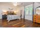 Bright bedroom featuring hardwood floors, a patterned headboard, a ceiling fan, and two dressers at 210 Hunters Vw, Roswell, GA 30075