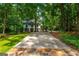 Stately two-story home nestled among mature trees with a long private driveway and stone accents at 210 Hunters Vw, Roswell, GA 30075