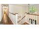Upstairs hallway with hardwood floors, white railings, and a view to the foyer below at 210 Hunters Vw, Roswell, GA 30075