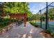 Relaxing patio with table and chairs next to the tennis court and professional landscaping at 210 Hunters Vw, Roswell, GA 30075