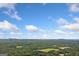 Expansive aerial view showcases the lush green landscape under a bright, cloudy sky at 3 Maplelake Dr, Acworth, GA 30101