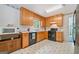 Functional kitchen with black appliances, wood cabinets, and a view of the sink from the window at 3 Maplelake Dr, Acworth, GA 30101