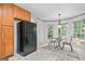 Eat-in kitchen featuring wood cabinetry, a black refrigerator, and a table next to a big window at 3 Maplelake Dr, Acworth, GA 30101