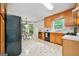 Eat-in kitchen featuring wood cabinetry, a black refrigerator, and a table next to a big window at 3 Maplelake Dr, Acworth, GA 30101