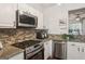 Stylish kitchen featuring stainless steel appliances, stone backsplash, and granite counters at 1911 Stancrest Nw Trce, Kennesaw, GA 30152