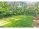 Spacious backyard featuring an expansive lawn, mature trees, and wooden fence perimeter at 222 Bishop Ne Dr, Marietta, GA 30060