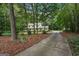 Two-story home surrounded by trees, featuring a long driveway and landscaped front yard at 2110 Waterloo Cir, Lawrenceville, GA 30043