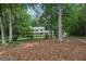 Two-story home surrounded by trees, featuring a long driveway and landscaped front yard at 2110 Waterloo Cir, Lawrenceville, GA 30043