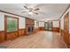 Open living room featuring wood paneling, a brick fireplace, and wood-look flooring at 2110 Waterloo Cir, Lawrenceville, GA 30043