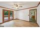 Bright living area with wood-look flooring, ceiling fan, and double doors to deck at 2110 Waterloo Cir, Lawrenceville, GA 30043