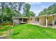 Backyard view of home featuring brick exterior, lawn, mature trees, and screened in porch at 3332 St John Dr, East Point, GA 30344