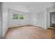 Sunlit bedroom featuring wood floors, a ceiling fan, closet, and a large window with leafy views at 3332 St John Dr, East Point, GA 30344