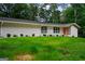 Ranch home with white brick exterior, green lawn, and an orange front door at 3332 St John Dr, East Point, GA 30344