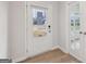 View of a home's entryway with light hardwood floors, white walls, and a door leading to the outside at 3614 Squires Park Ln, Loganville, GA 30052