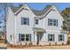 Charming two-story home with light-blue siding, dark shutters, brick foundation, and well-manicured landscaping at 3614 Squires Park Ln, Loganville, GA 30052