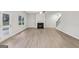 Bright, spacious living room featuring light hardwood floors, a ceiling fan, a fireplace, and a door to the backyard at 3614 Squires Park Ln, Loganville, GA 30052