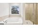 This spa bathroom features a soaking tub, separate shower and granite countertops at 3623 Squires Park Ln, Loganville, GA 30052