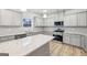 This kitchen has stainless appliances, gray cabinets and light countertops with an island at 3623 Squires Park Ln, Loganville, GA 30052
