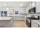 This kitchen has stainless appliances, gray cabinets and light countertops with an island at 3623 Squires Park Ln, Loganville, GA 30052