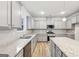 This kitchen has stainless appliances, gray cabinets and light countertops with an island at 3623 Squires Park Ln, Loganville, GA 30052