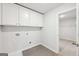 This well-lit laundry room includes storage cabinets and space for a washer and dryer at 3623 Squires Park Ln, Loganville, GA 30052