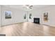 Sunlit living room with hardwood floors, fireplace, and views of the backyard at 3623 Squires Park Ln, Loganville, GA 30052