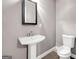 Bright bathroom with a sleek pedestal sink, modern mirror, and tiled flooring at 644 Albert Nw St, Atlanta, GA 30318