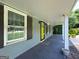 View of the covered front porch with a bright yellow door and a window with dark shutters at 644 Albert Nw St, Atlanta, GA 30318