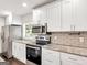 Updated kitchen with granite countertops, stainless steel appliances, and white cabinets at 644 Albert Nw St, Atlanta, GA 30318