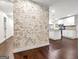 Spacious living room with refinished brick wall and hardwood floors that flow into the kitchen at 644 Albert Nw St, Atlanta, GA 30318