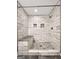 Close-up of tiled shower with integrated bench seating and river rock floor at 644 Albert Nw St, Atlanta, GA 30318