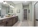 Bright bathroom with double vanity, wood cabinets, a large mirror and tile floors at 2 Silver Leaf Trl, Douglasville, GA 30134