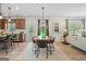 Open-concept dining area with modern table, seating, and views of the kitchen and living room at 2 Silver Leaf Trl, Douglasville, GA 30134