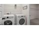 A functional laundry room with a washer, dryer, and shelving at 2 Silver Leaf Trl, Douglasville, GA 30134