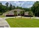 An elegant two-story home features a circular driveway, lush lawn, palm trees and landscaping and a beautiful facade at 345 Peaceful Way, Fayetteville, GA 30214